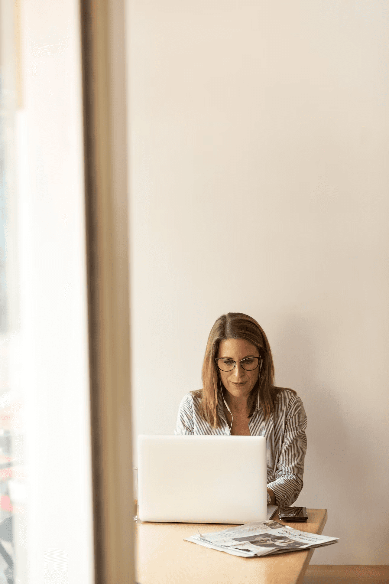 A woman working comfortably at her laptop in a bright, calm room