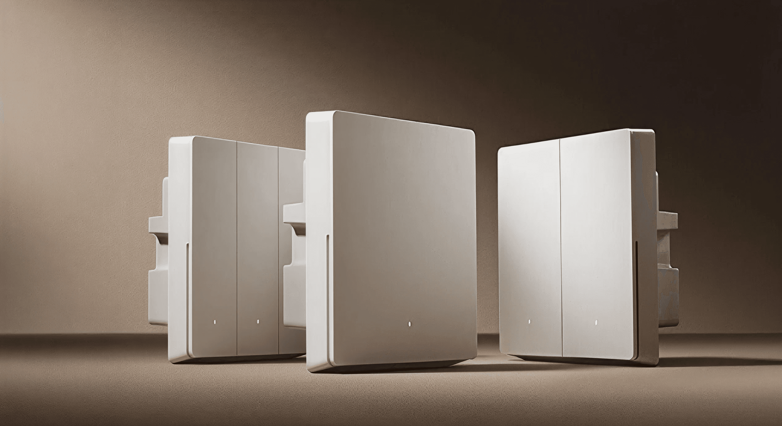 Trio of sculptural Lumira switches under warm studio light